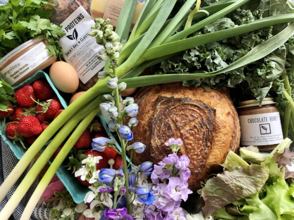A local farmers market table with produce and goods